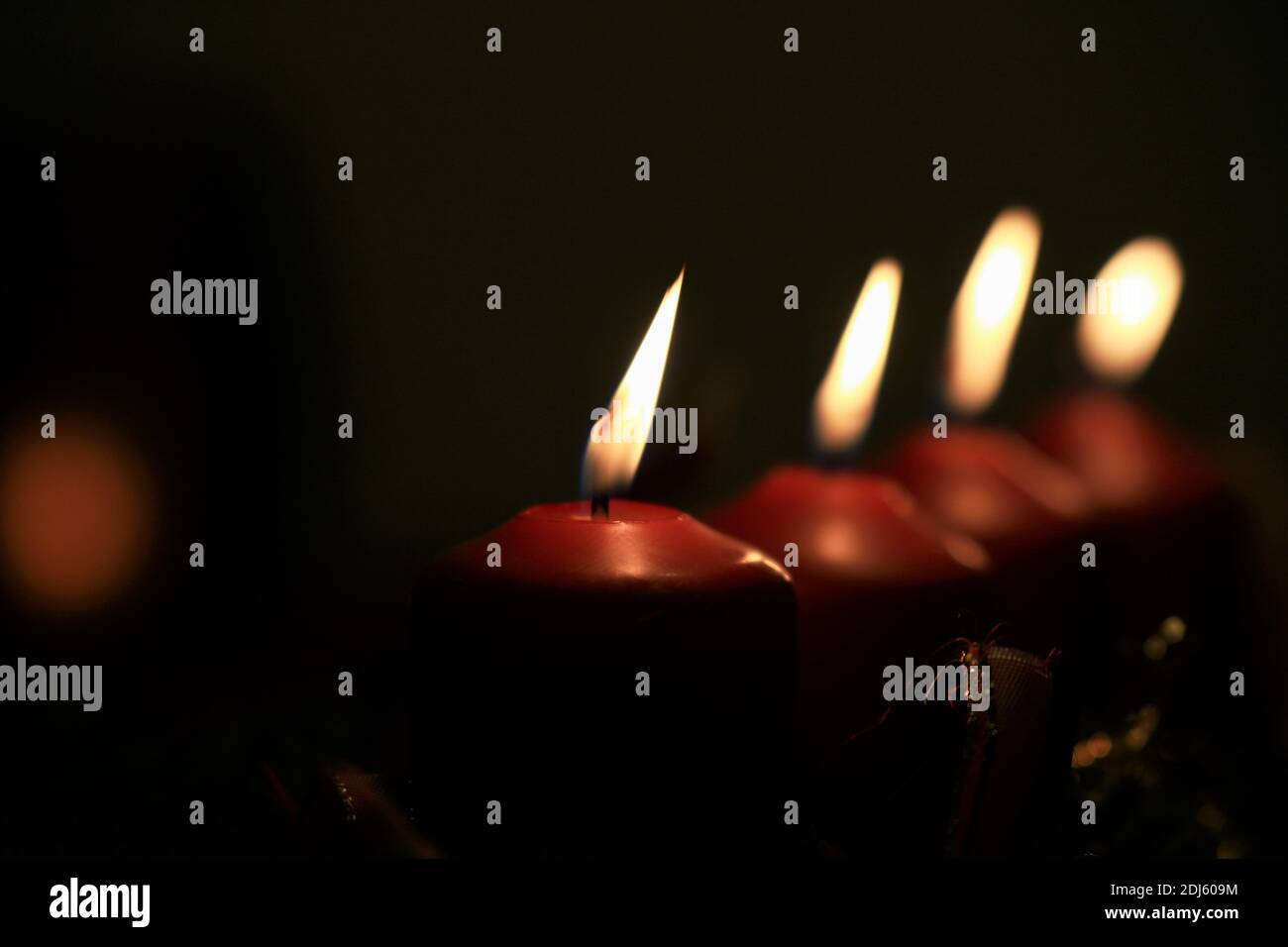 Nahaufnahme eines Adventsarrangements mit vier brennenden Kerzen Stockfoto