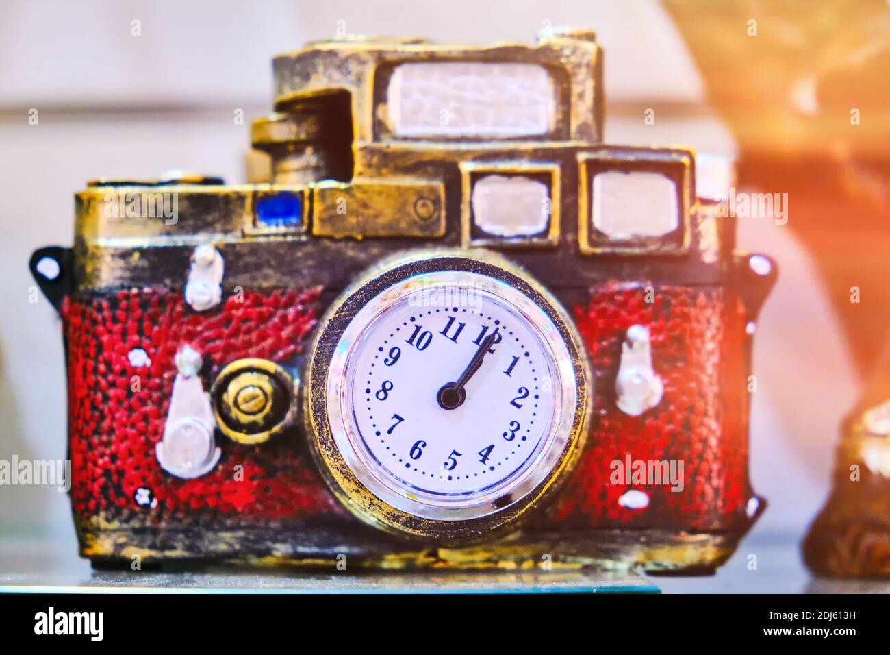 Eine alte Kamera mit Uhr ist ein Konzept einer Zeitmaschine. Souvenir mit einem Uhrensymbol anstelle einer Linse Stockfoto