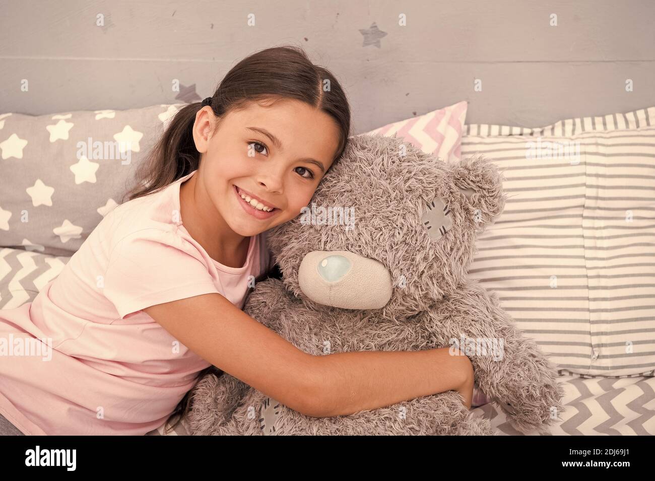 Täuschen Sie Freund vor. Fröhlicher Kid kuscheln Teddybär. Kleines Mädchen lächelt mit Spielzeugfreundin. Freund und Freundschaft. Adoption und Adoptivkind. Spiele spielen. Kinderzimmer. Glückliche Kindheit. Bester Freund. Stockfoto