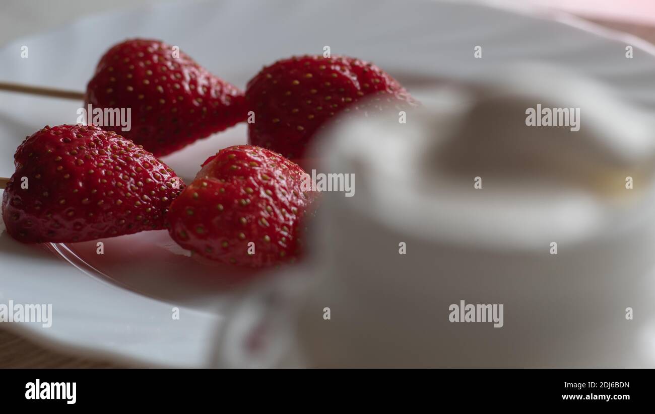 Erdbeeren mit Joghurt oder Sahne aus dem Fokus Stockfoto