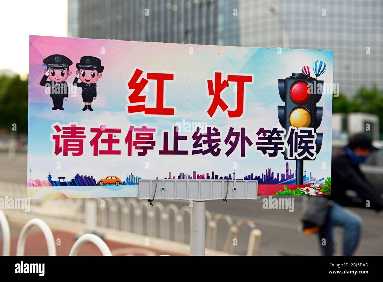 A Bitte halten Sie an und warten Sie außerhalb der Linie, wenn rote Ampel zeigt' Zeichen auf einer Straße in Peking, China Stockfoto