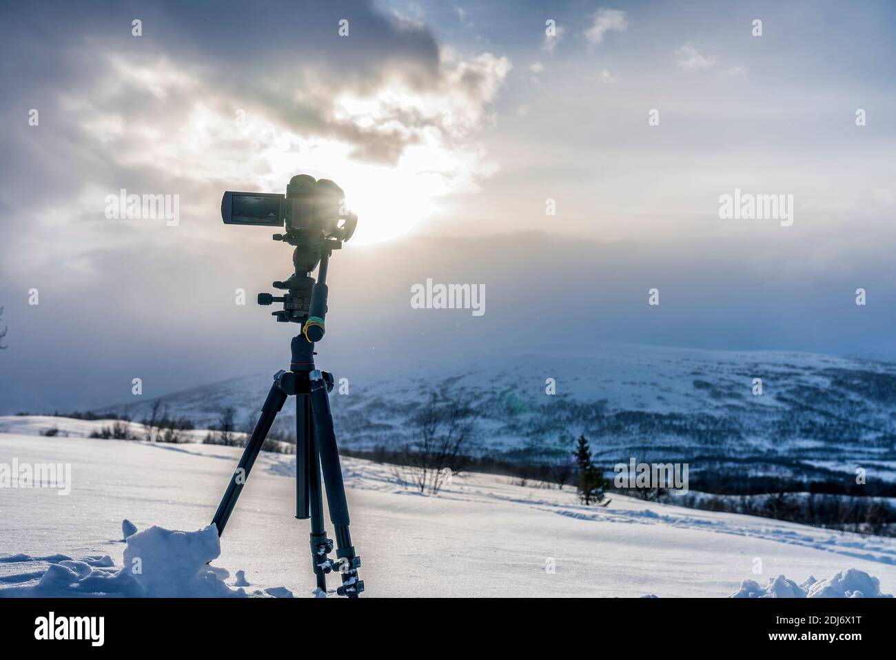 Aufnahme einer schönen Aussicht auf die Berglandschaft mit professioneller Videokamera, Stativaufnahme, Nahaufnahme. Sonne, Wolken, Winterblick Stockfoto