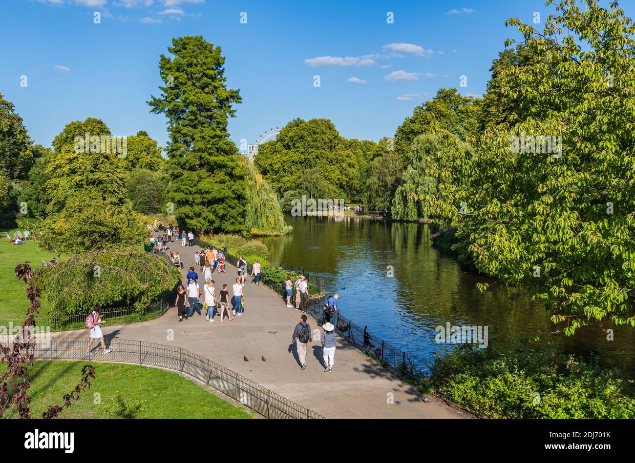 Anzeigen von Menschen zu Fuß im Sommer durch den See und die Gärten von St James's Park, Westminster, London, England, UK. St. James Park. Stockfoto