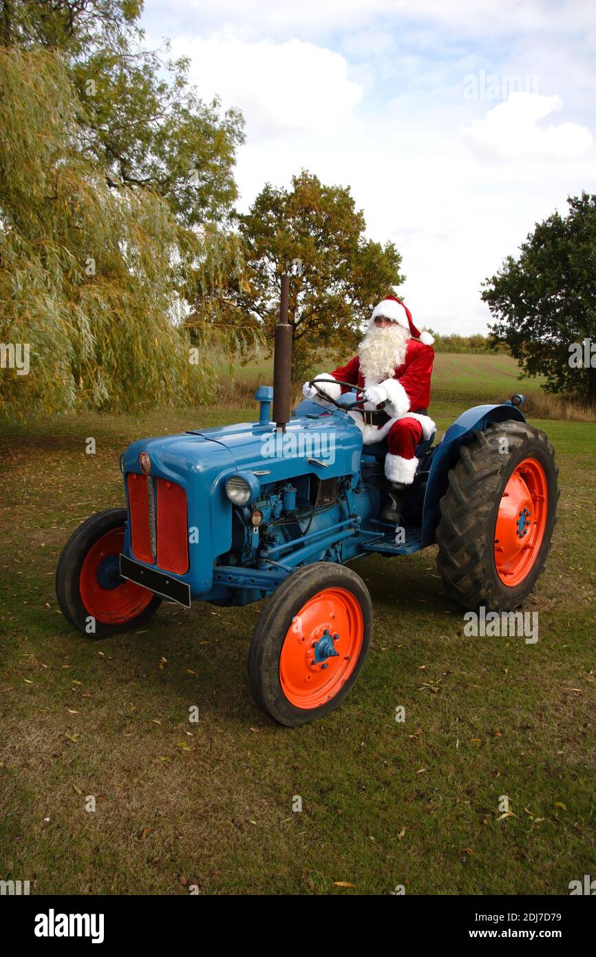 Vater Weihnachten fahren einen Fordson Dexta blauen Traktor in einem Wiese Stockfoto