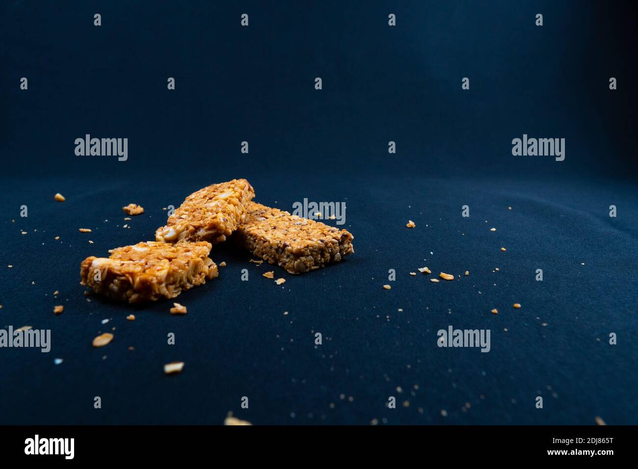 Fitness Müsliriegel mit Stücken auf schwarzem Hintergrund Stockfoto