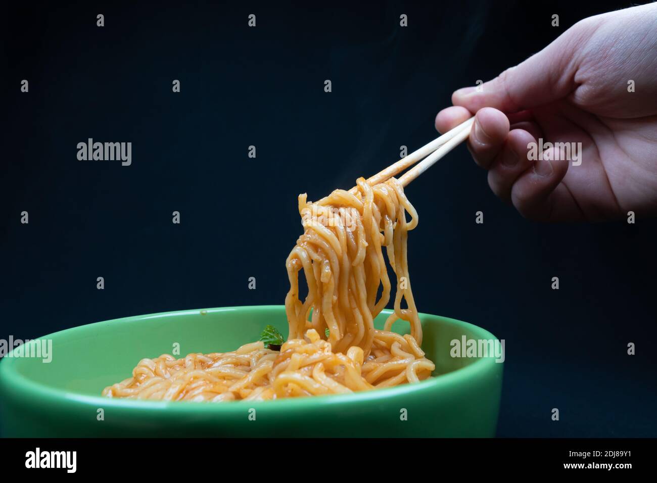 Hühnchen Schezwan Noodles oder Hakka oder Chow Mein in schwarzer Schale auf dunklem Hintergrund. Stockfoto