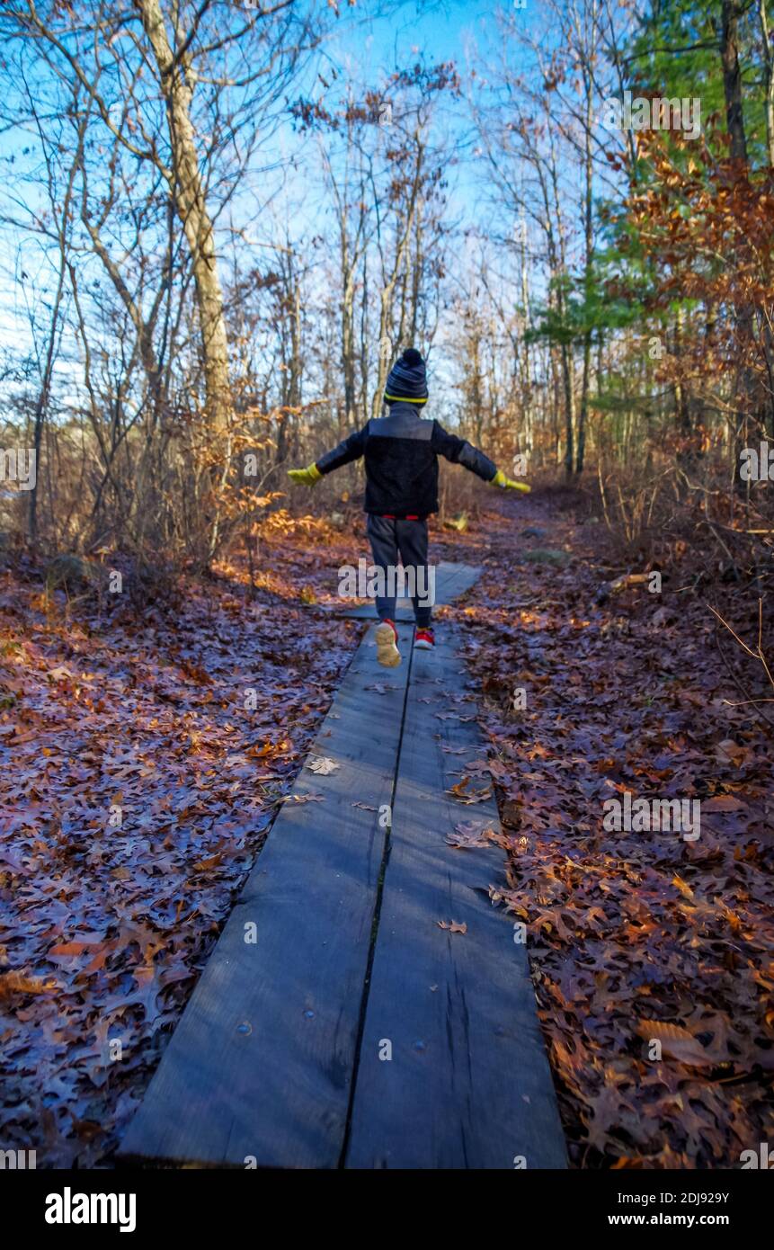 Kinderspringen auf dem Boardwalk im Ames Nowell State Park, Abington, Massachusetts, USA Stockfoto
