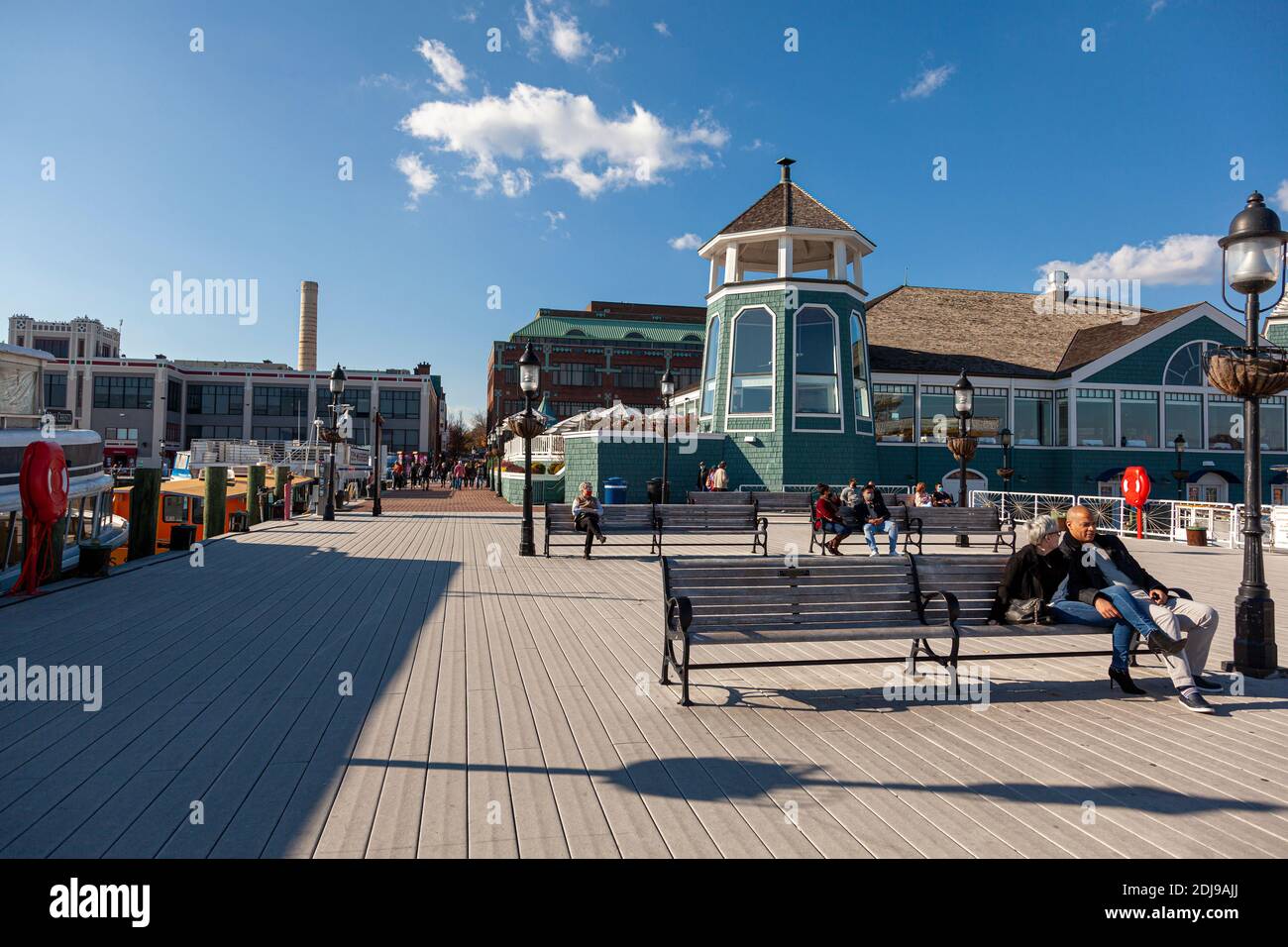 Alexandria, VA, USA 11-28-2020: Ein sonniger Tag am Ufer des alten Stadtteils von Alexandria mit Menschen sitzen auf Bänken auf dem Pier in FRO Stockfoto