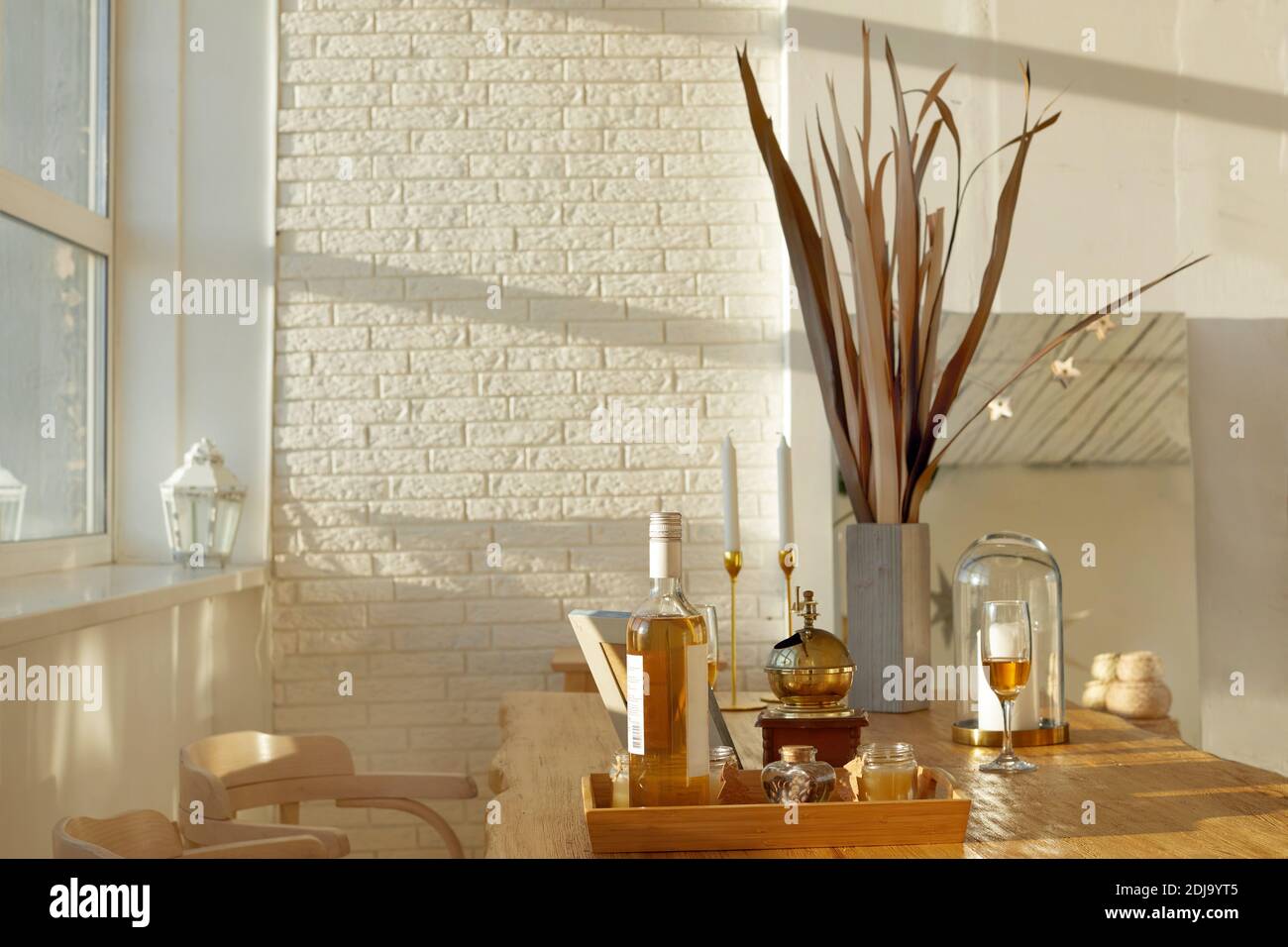 Tisch mit Wein und Snacks in der Nähe von Stühlen in gemütlich Eleganter Speisesaal zu Hause Stockfoto