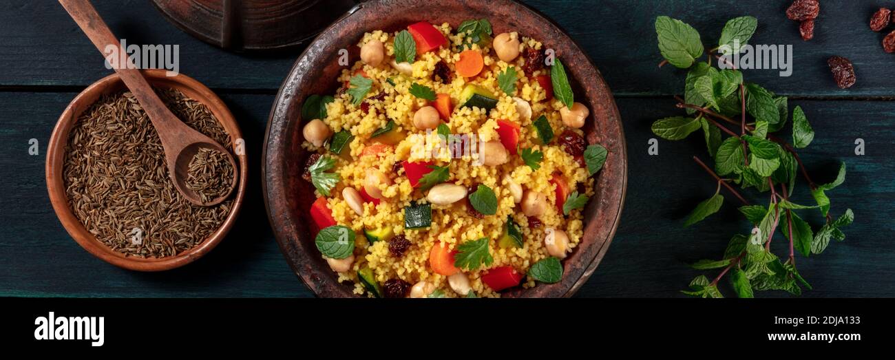 Couscous Panorama mit Zutaten, Top-Shot auf dunklem Hintergrund Stockfoto