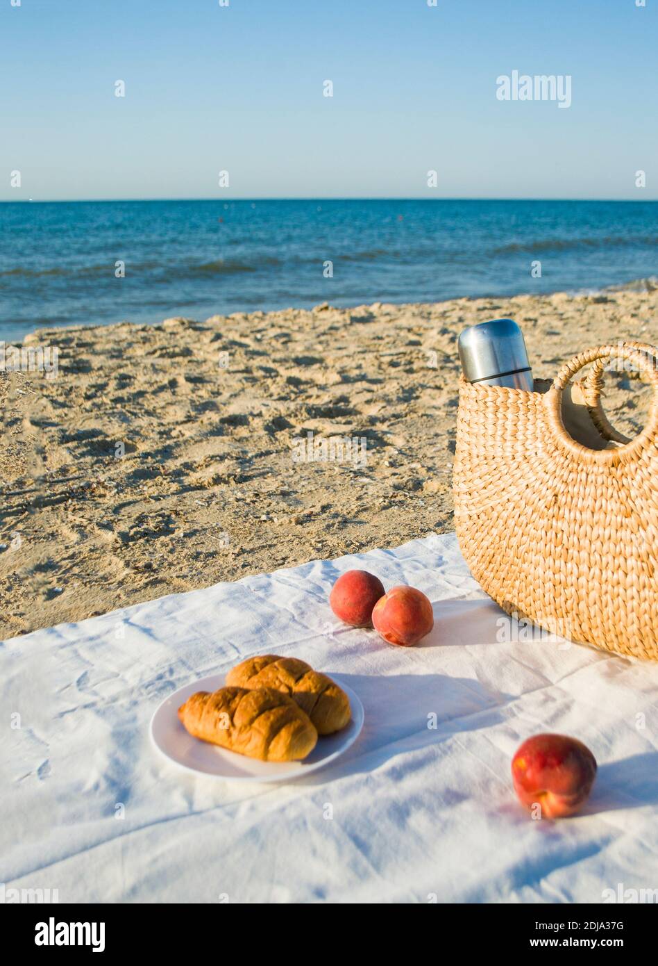 Sommer Picknick am Strand durch das Meer bei Sonnenaufgang. Stockfoto