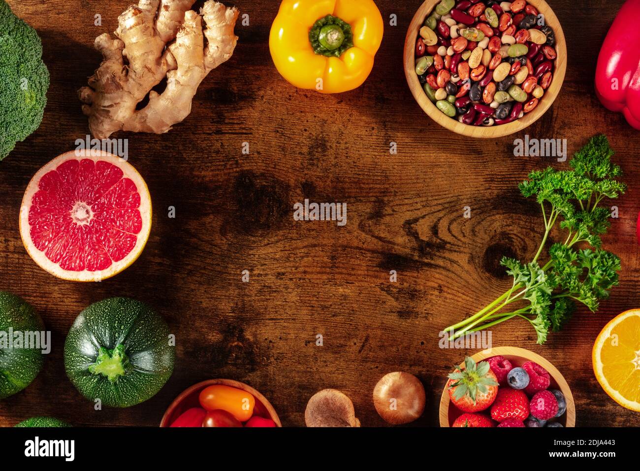 Vegane Lebensmittel Rahmen mit einem Platz für Text. Gesunde Superfoods, aufgenommen von oben auf einem dunklen rustikalen Holzhintergrund Stockfoto