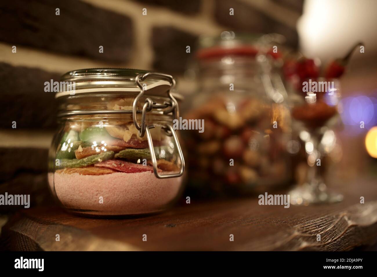 Kandierte Früchte mit Zucker im Glas auf Holzbrett Stockfoto