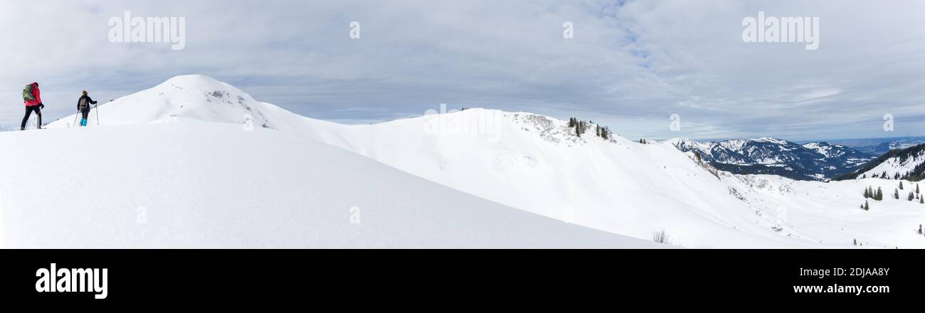 Seniorenpaar ist Schneeschuhwandern im alpinen Schnee Winter Berge Panorama. Allgau, Bayern, Deutschland. Stockfoto