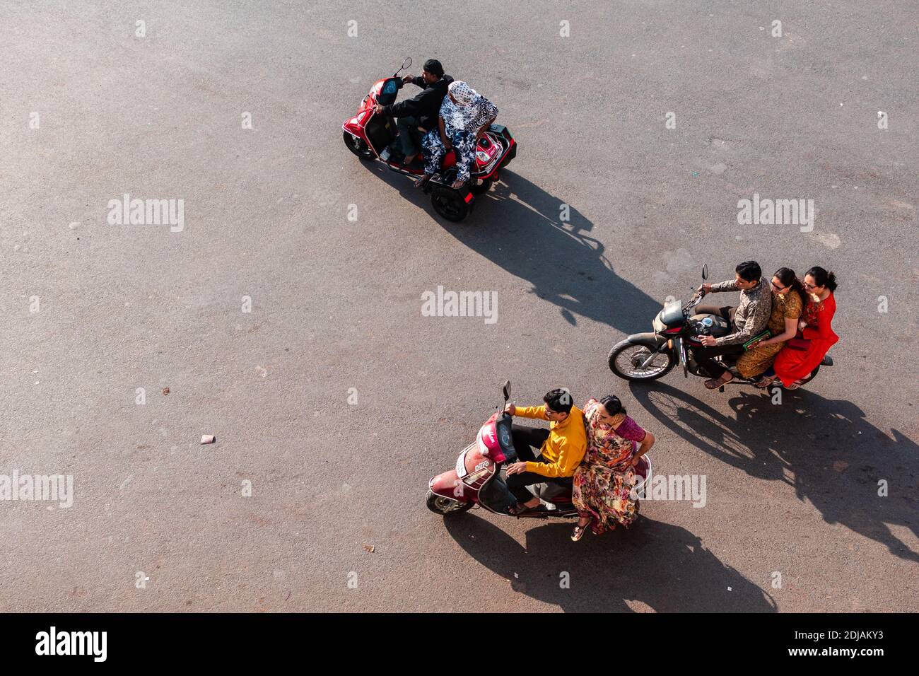 Jamnagar, Gujarat, Indien   Dezember 2018: Luftaufnahme von Motorrädern, die indische Familien tragen, die auf einer Straße in der Stadt fahren. Stockfoto