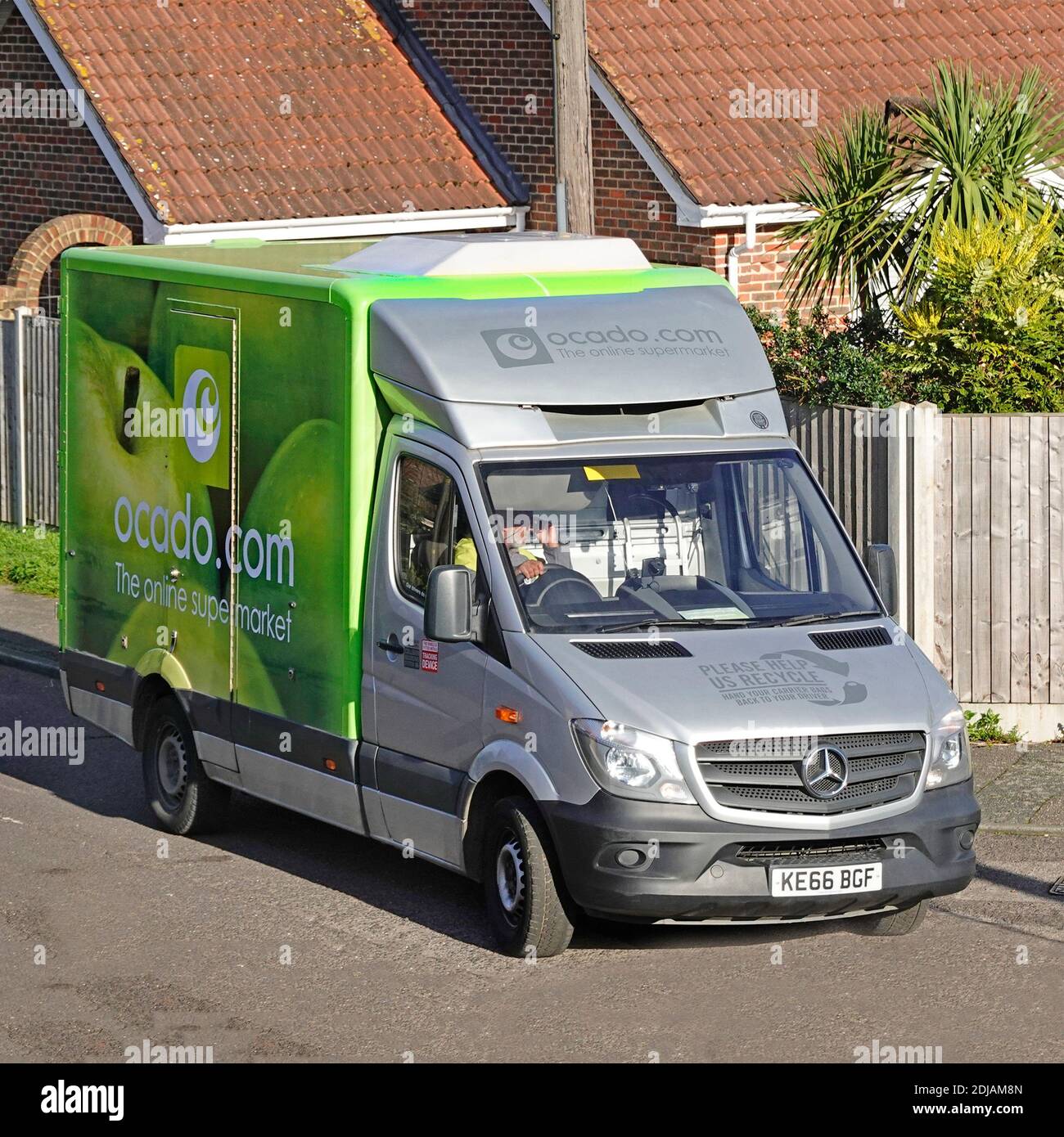 Seite & Vorderansicht von oben mit Blick auf grün Ocado Online Lebensmittel Lebensmittel einkaufen Lieferung van & Logo Fahrer Fahren Wohnstraße England Großbritannien Stockfoto