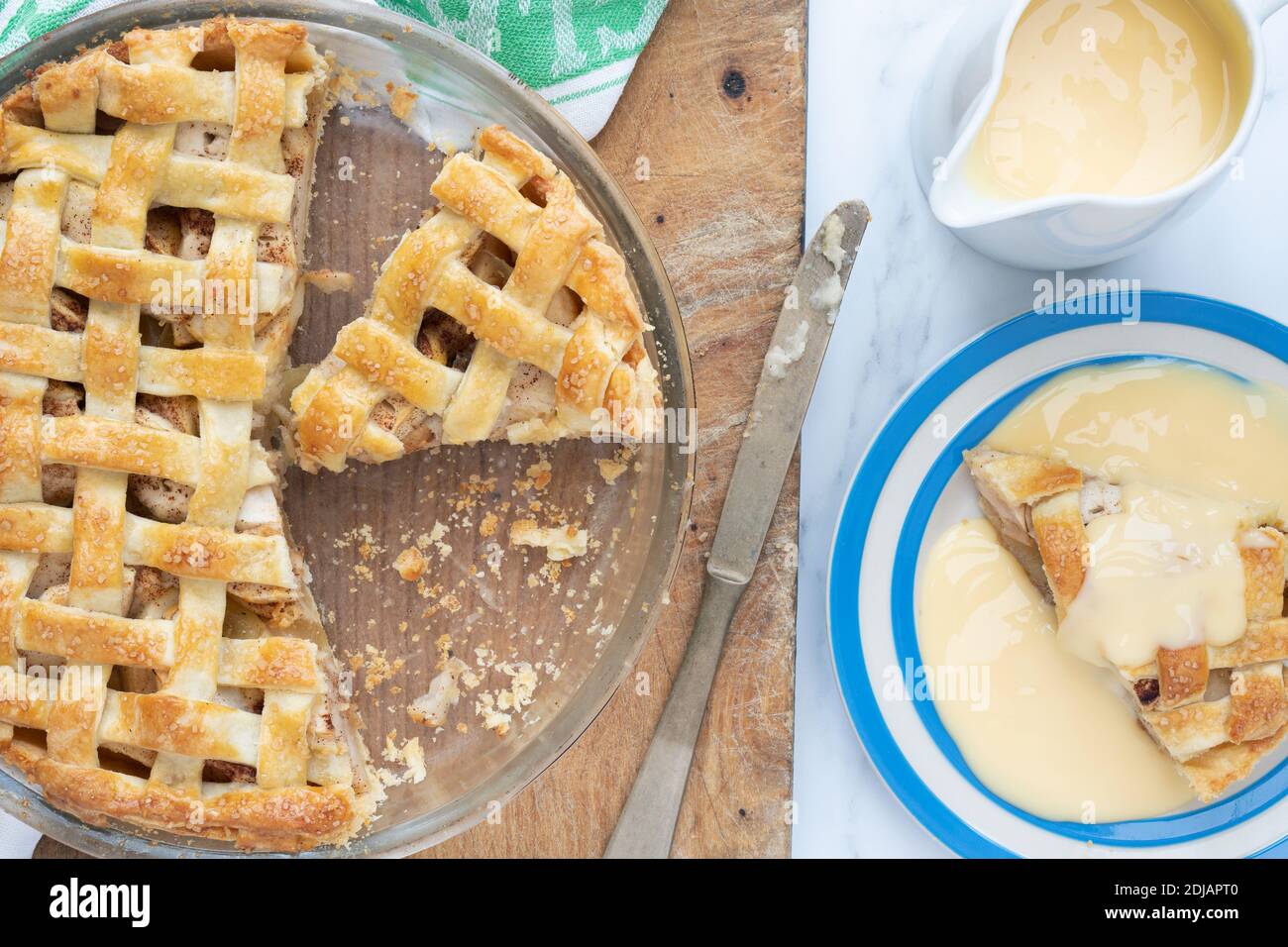 Hausgemachter Apfelkuchen mit einer Gitterplatte und Pudding Stockfoto