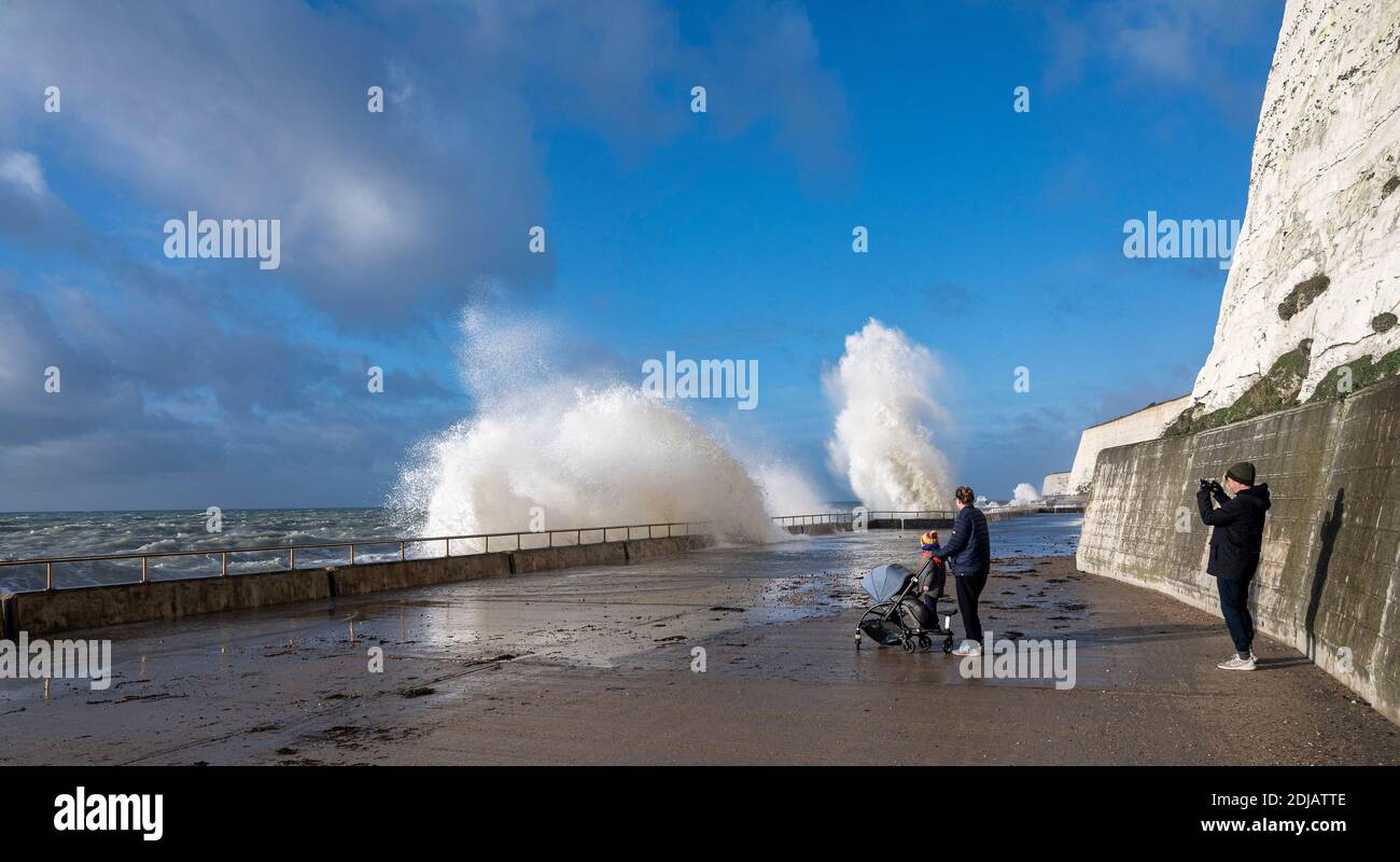Brighton UK 14. Dezember 2020 - Spaziergänger beobachten die Wellen an einem windigen Tag entlang der Saltdean undercliff Walk an der Strandpromenade in der Nähe von Brighton bei Flut . Die Wettervorhersage ist für stärkere Winde und Duschen, um über Teile von Großbritannien zu verbreiten, aber mit Temperaturen, die wärmer als in den letzten Tagen sind : Credit Simon Dack / Alamy Live News Stockfoto