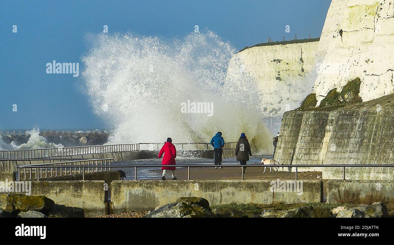 Brighton UK 14. Dezember 2020 - Wanderer beobachten die Wellen, die entlang der Saltdean undercliff an einem windigen Tag in der Nähe von Brighton heute bei Flut einstürzen. Die Wettervorhersage ist für stärkere Winde und Duschen, um über Teile von Großbritannien zu verbreiten, aber mit Temperaturen, die wärmer als in den letzten Tagen sind : Credit Simon Dack / Alamy Live News Stockfoto