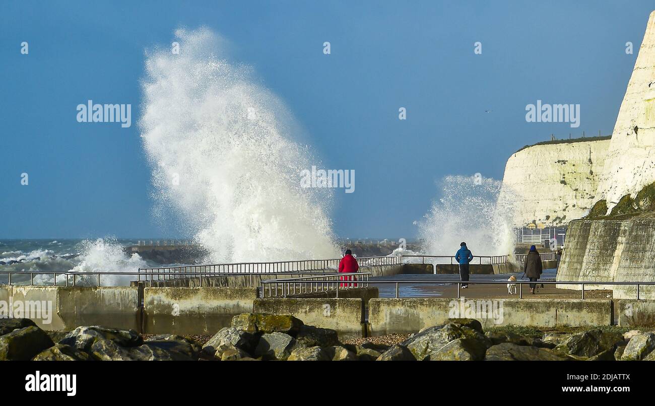 Brighton UK 14. Dezember 2020 - Wanderer beobachten die Wellen, die entlang der Saltdean undercliff an einem windigen Tag in der Nähe von Brighton heute bei Flut einstürzen. Die Wettervorhersage ist für stärkere Winde und Duschen, um über Teile von Großbritannien zu verbreiten, aber mit Temperaturen, die wärmer als in den letzten Tagen sind : Credit Simon Dack / Alamy Live News Stockfoto