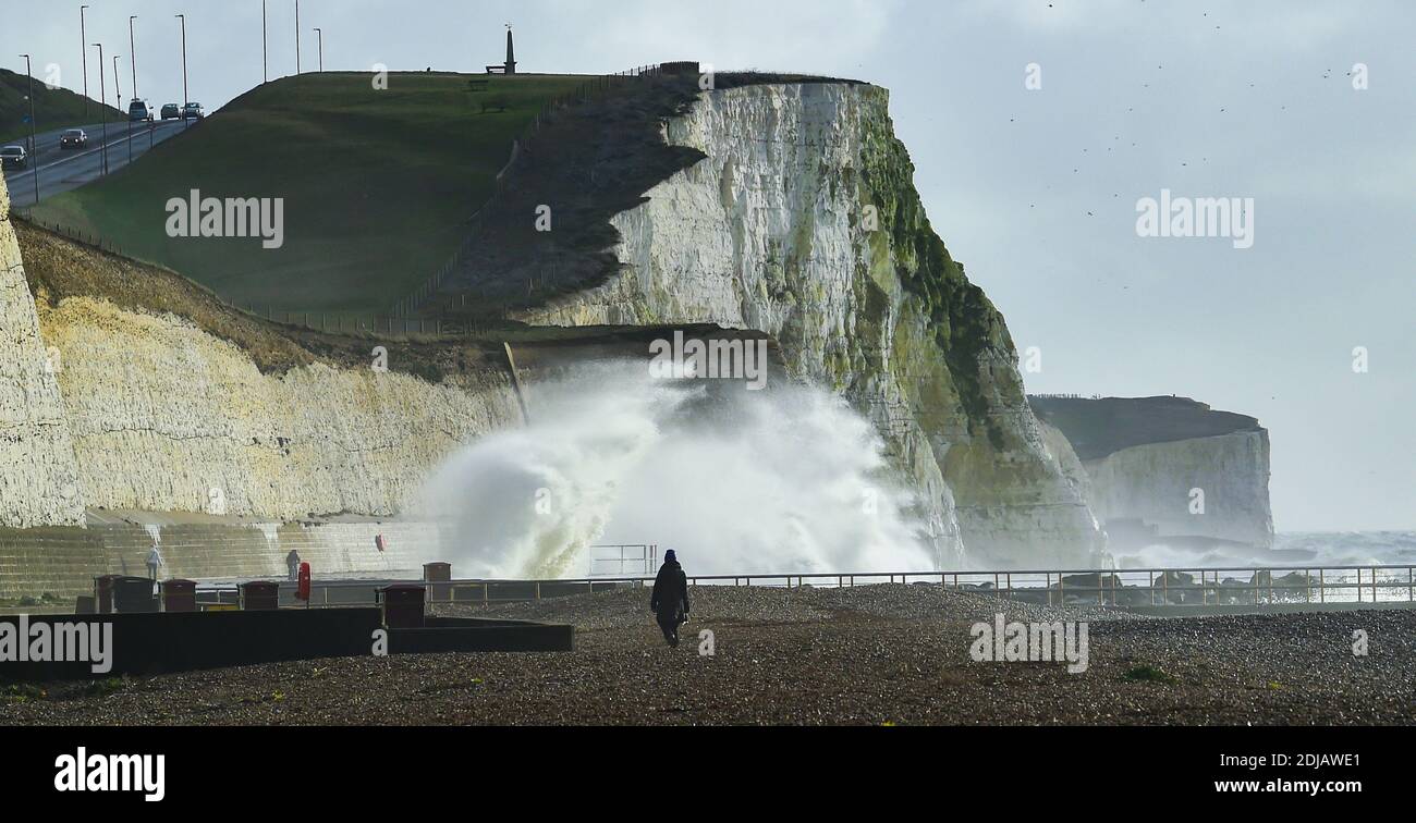 Brighton UK 14. Dezember 2020 - Spaziergänger beobachten die Wellen an einem windigen Tag am Saltdean Strand in der Nähe von Brighton heute bei Flut . Die Wettervorhersage ist für stärkere Winde und Duschen, um über Teile von Großbritannien zu verbreiten, aber mit Temperaturen, die wärmer als in den letzten Tagen sind : Credit Simon Dack / Alamy Live News Stockfoto