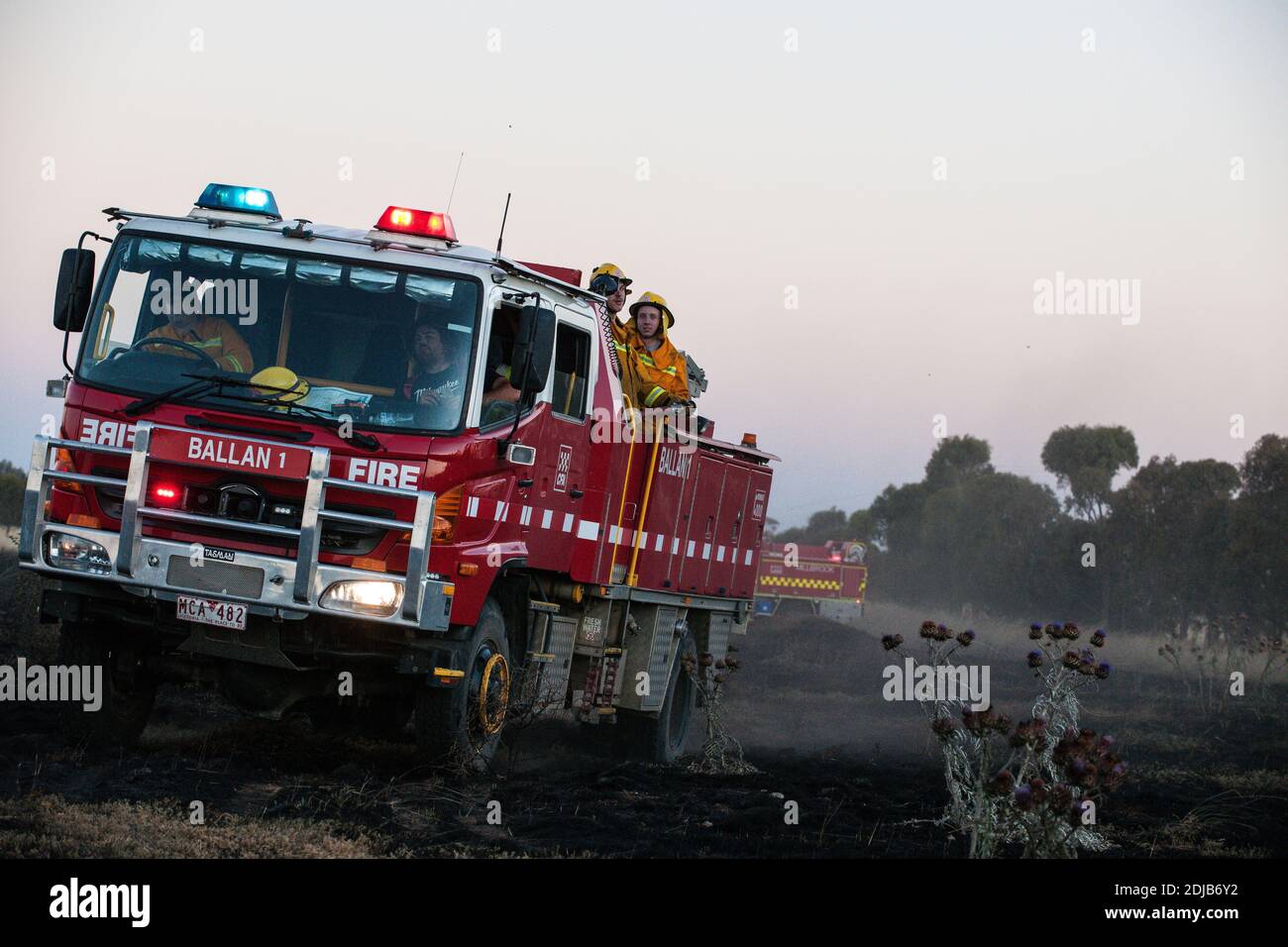 Melbourne, Australien 14 Dec 2020, EIN Feuerwehrauto der County Fire Authority bewegt sich mit seiner Crew über die verbrannten Fahrerlager in der Nähe von Mount Cottrell. Die Feuerwehr hat mit Flugzeugen und Feuerwehrmannschaften einen 110 Hektar großen Grasbrand im äußersten Westen Melbournes kontrolliert, der mehrere Schuppen und Autos zerstört. Stockfoto