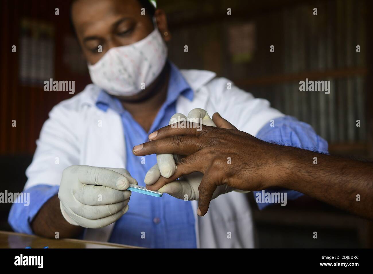 Agartala, Indiens nordöstlicher Bundesstaat Tripura. Dezember 2020. Ein Gesundheitsmitarbeiter testet das Blut eines Fahrers an einem Bussstand während eines Beratungs- und HIV-Testcamps, das von der staatlichen AIDS-Kontrollgesellschaft Tripura in Agartala, der Hauptstadt des nordöstlichen indischen Bundesstaates Tripura, am 14. Dezember 2020 organisiert wurde. Quelle: Str/Xinhua/Alamy Live News Stockfoto