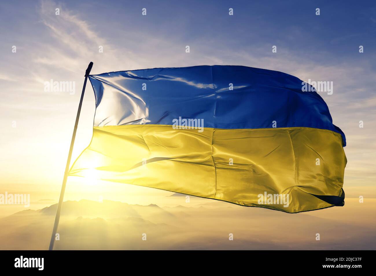 Ukraine Flagge winkt auf der Oberseite Sonnenaufgang Nebel Stockfoto