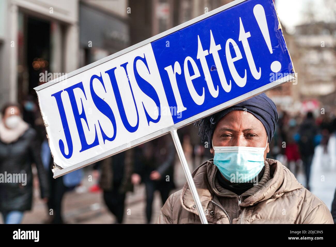 Eine Frau mit Mund- und Nasenschutz trägt ein Zeichen, das Jesus RETTET liest! Durch die Fußgängerzone Westenhellweg in Dortmund --- eine Frau mit Mund-Nasenschutz tragt während der Corona-Zeit ein Schild mit der Aufschrift JESUS RETTET! Durch die Fußgängerzone Westenhellweg in Dortmund Stockfoto