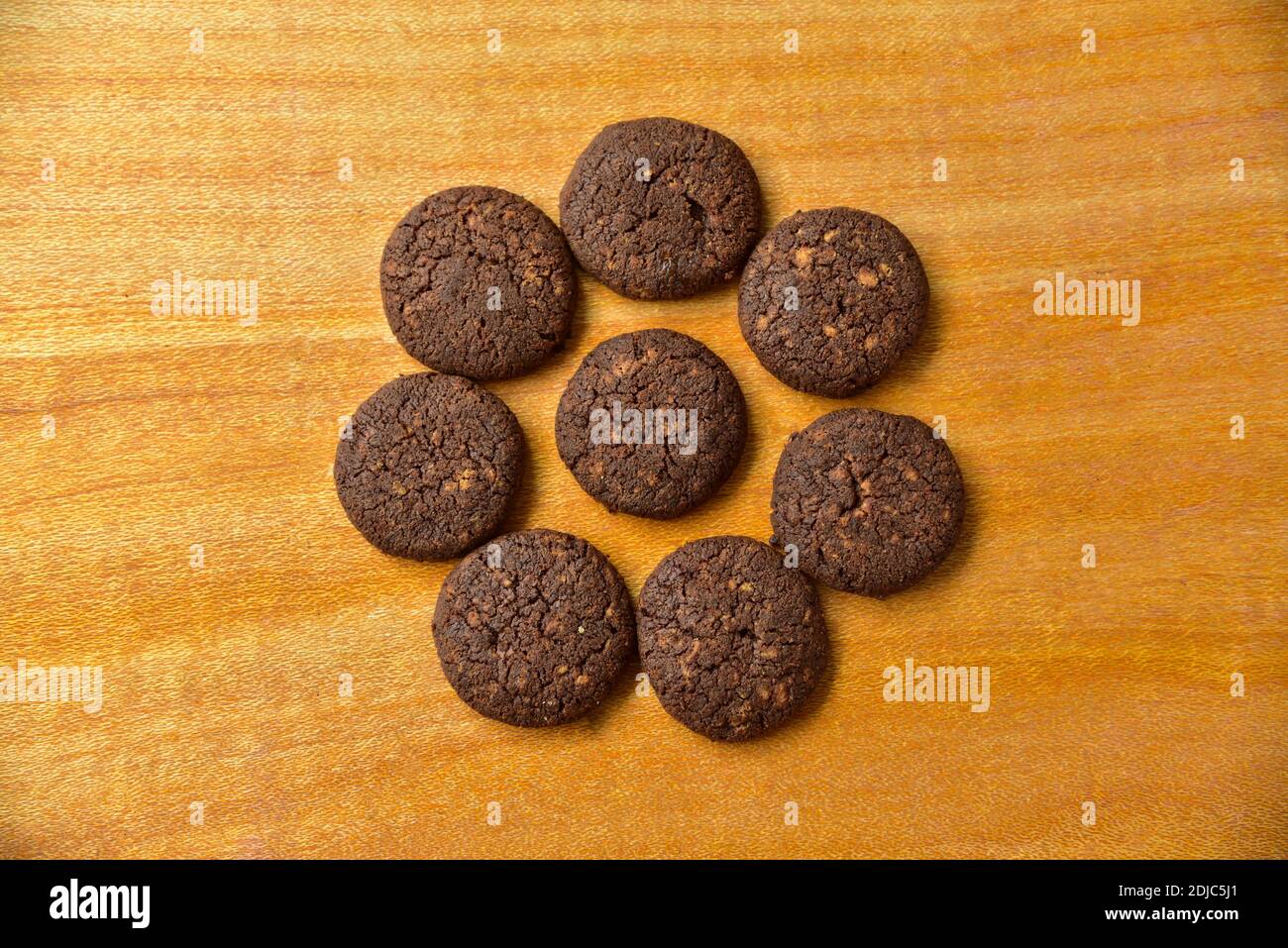 Schokoladenkekse in einem hölzernen Hintergrund. Schokoladenkekse mit Nüssen Draufsicht. Stockfoto