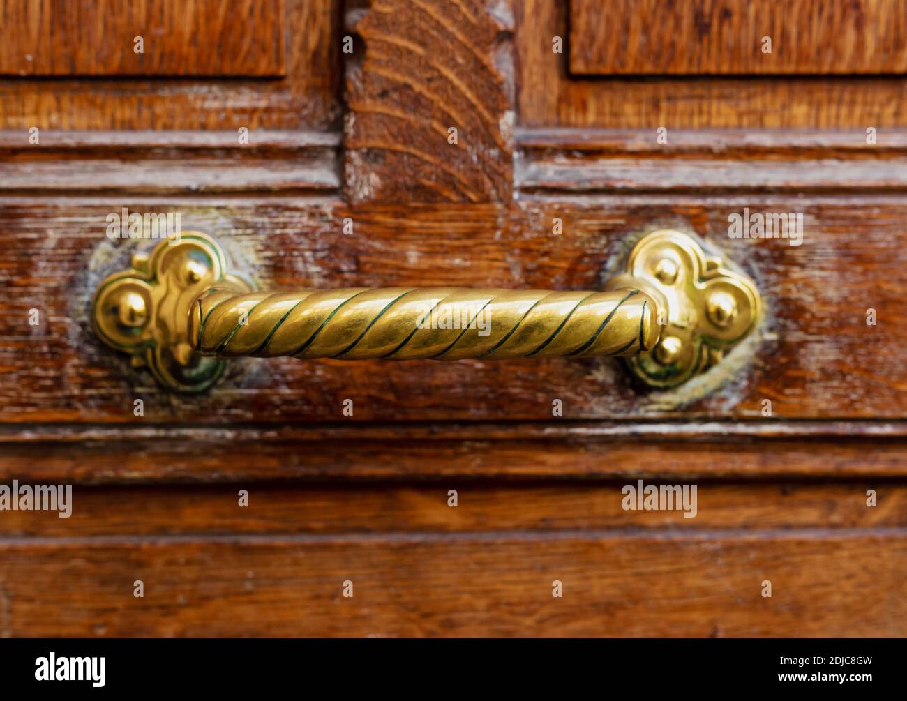 Alter Türgriff an alter brauner Holztür. Nahaufnahme Paris, Frankreich. Goldene Messingdetails an alter Holztür. Griff auf braunem alten Holz schäbig vintage Stockfoto
