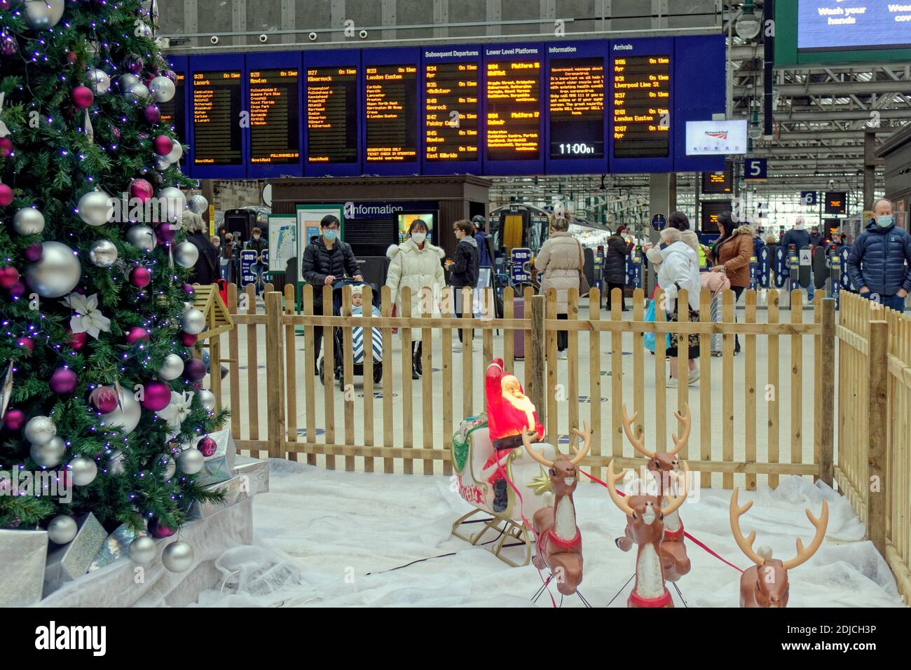 Glasgow, Schottland, Großbritannien, 14. Dezember 2020: Nicht wie Weihnachten in der Stadt, wie dumm Wetter und covid kombinieren, um den Geist zu senken und die Seele der Stadt zu zerstören.. Hauptbahnhof einer der wenigen öffentlichen Bereiche mit einer Anzeige und Krippe, aber nur wenige Reisende wegen covid.Credit: Gerard Ferry/Alamy Live News Stockfoto Glasgow, Schottland, Großbritannien, 14. Dezember 2020: Nicht wie Weihnachten in der Stadt, wie dumm Wetter und covid kombinieren, um den Geist zu senken und die Seele der Stadt zu zerstören.. Hauptbahnhof einer der wenigen öffentlichen Bereiche mit einer Anzeige und Krippe, aber nur wenige Reisende wegen covid.Credit: Gerard Ferry/Alamy Live News Stockfoto
