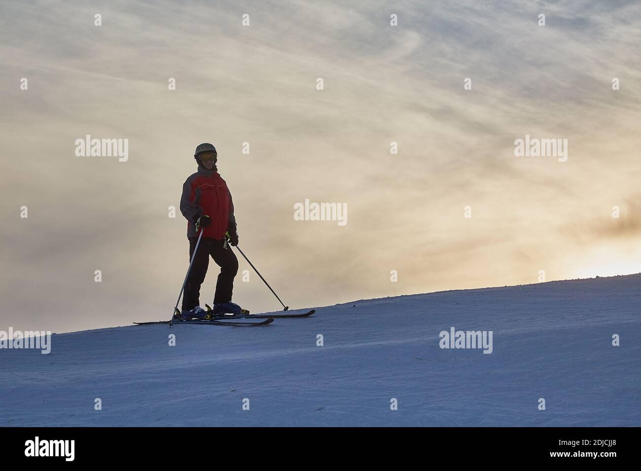 Skifahrer gegen glühenden Himmel Stockfoto
