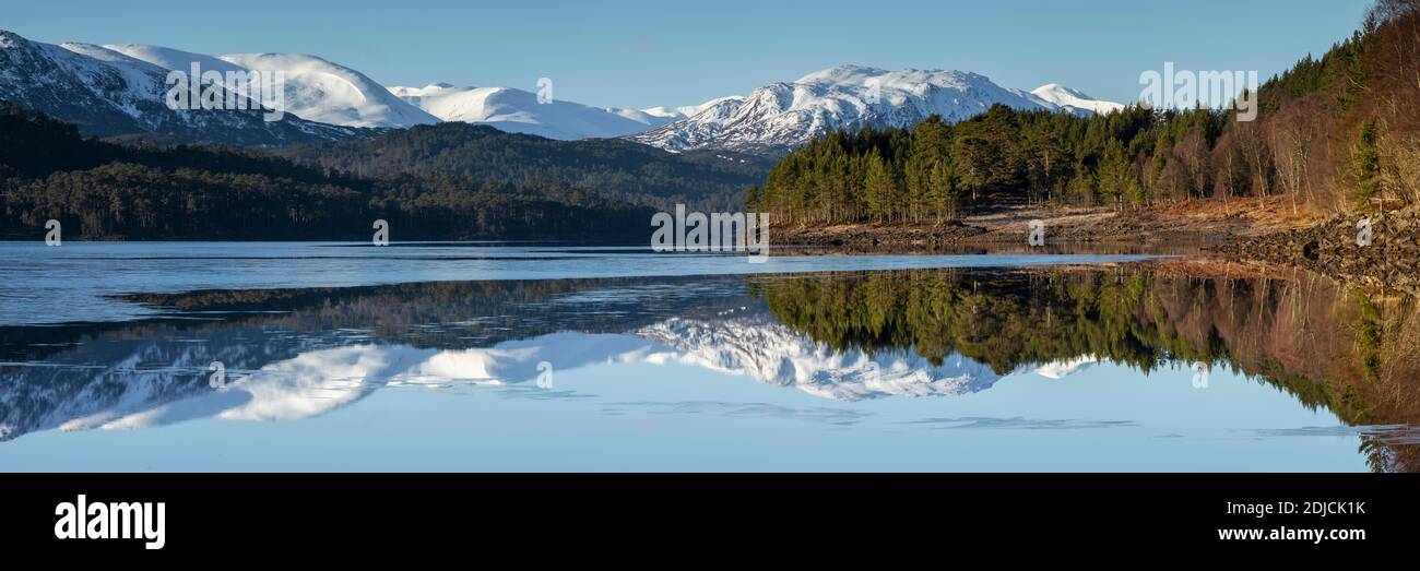 Weit entfernte schneebedeckte Berge spiegeln sich in Loch Beinn A' Mheadhoin, Glen Affric, Schottland Stockfoto