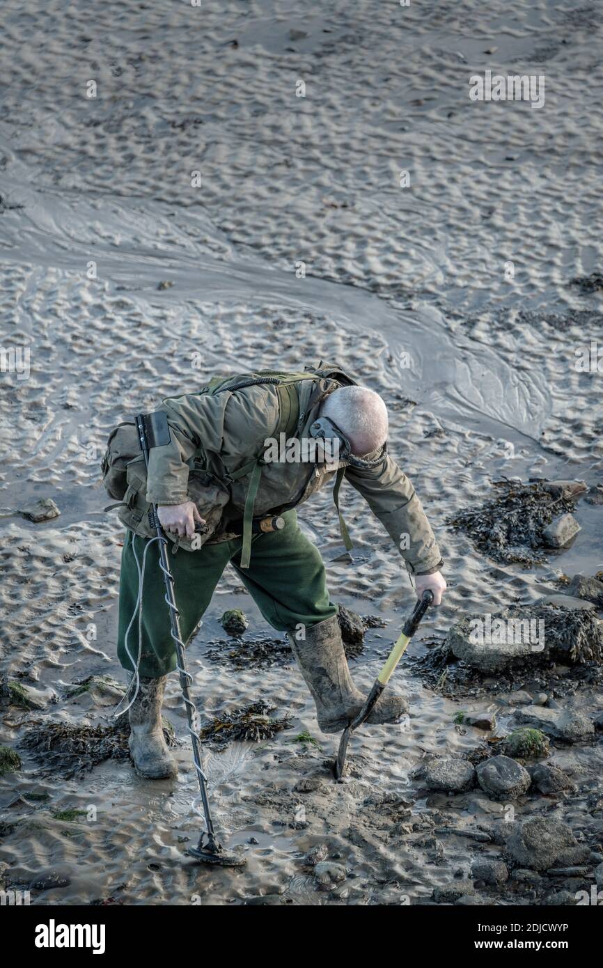 Ein Metalldetektor scannt den Strand nach versteckten Artefakten. Ein Metalldetektor ist ein elektronisches Instrument, das das Vorhandensein von metallischen Objekten erkennt b Stockfoto