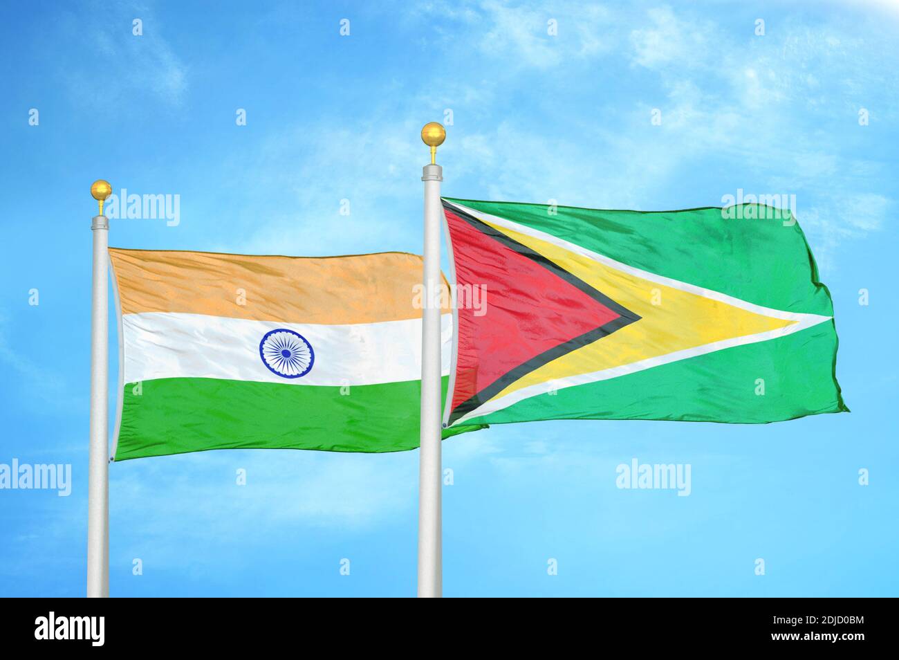 Indien und Guyana zwei Flaggen auf Fahnenmasten und blau bewölkt Himmel Stockfoto