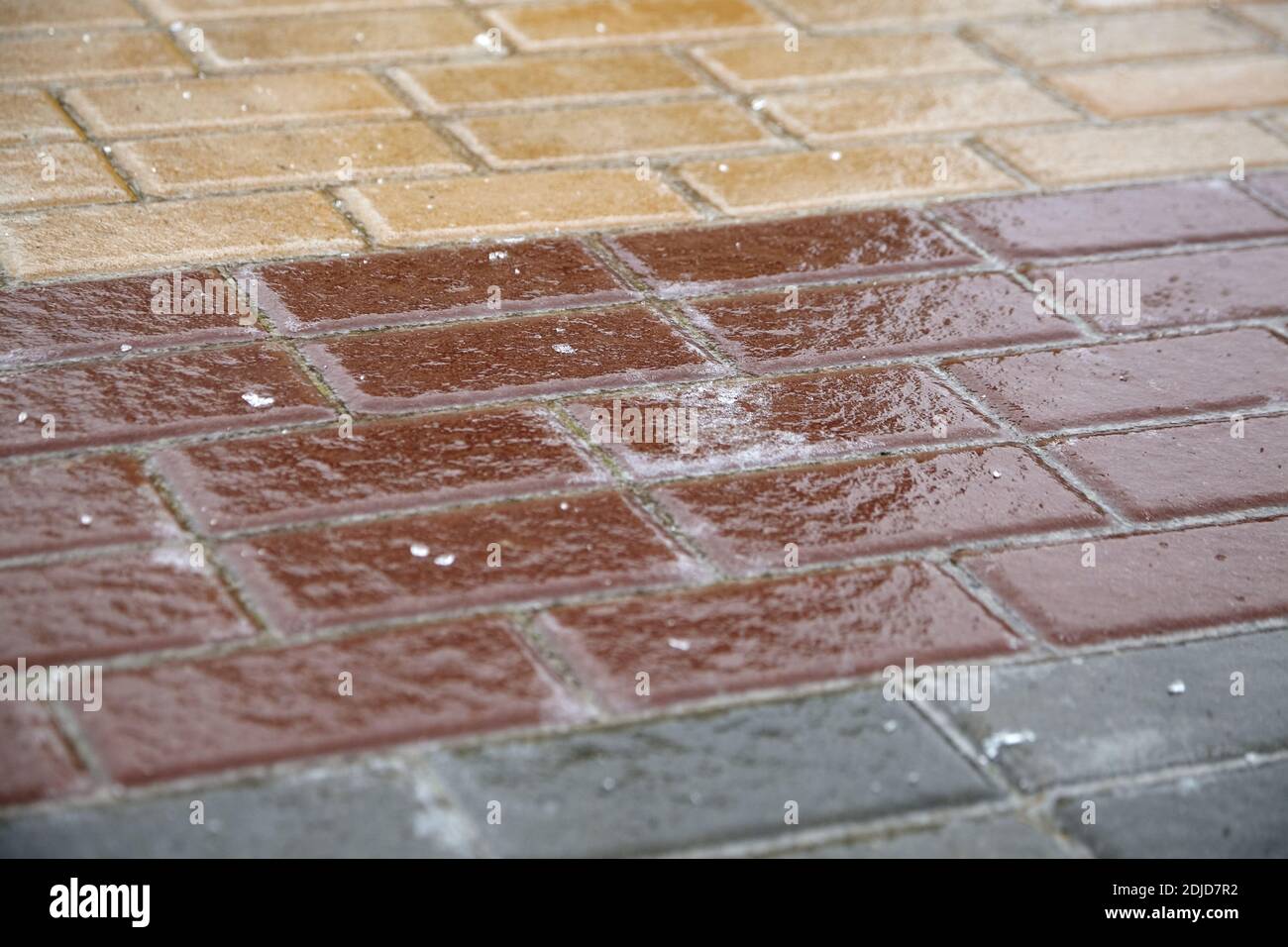 Eis verkrustet Boden, Pflasterplatten Oberfläche bedeckt Eis, rutschige Straße, Winterwetter. Vereister Seitenweg Stockfoto