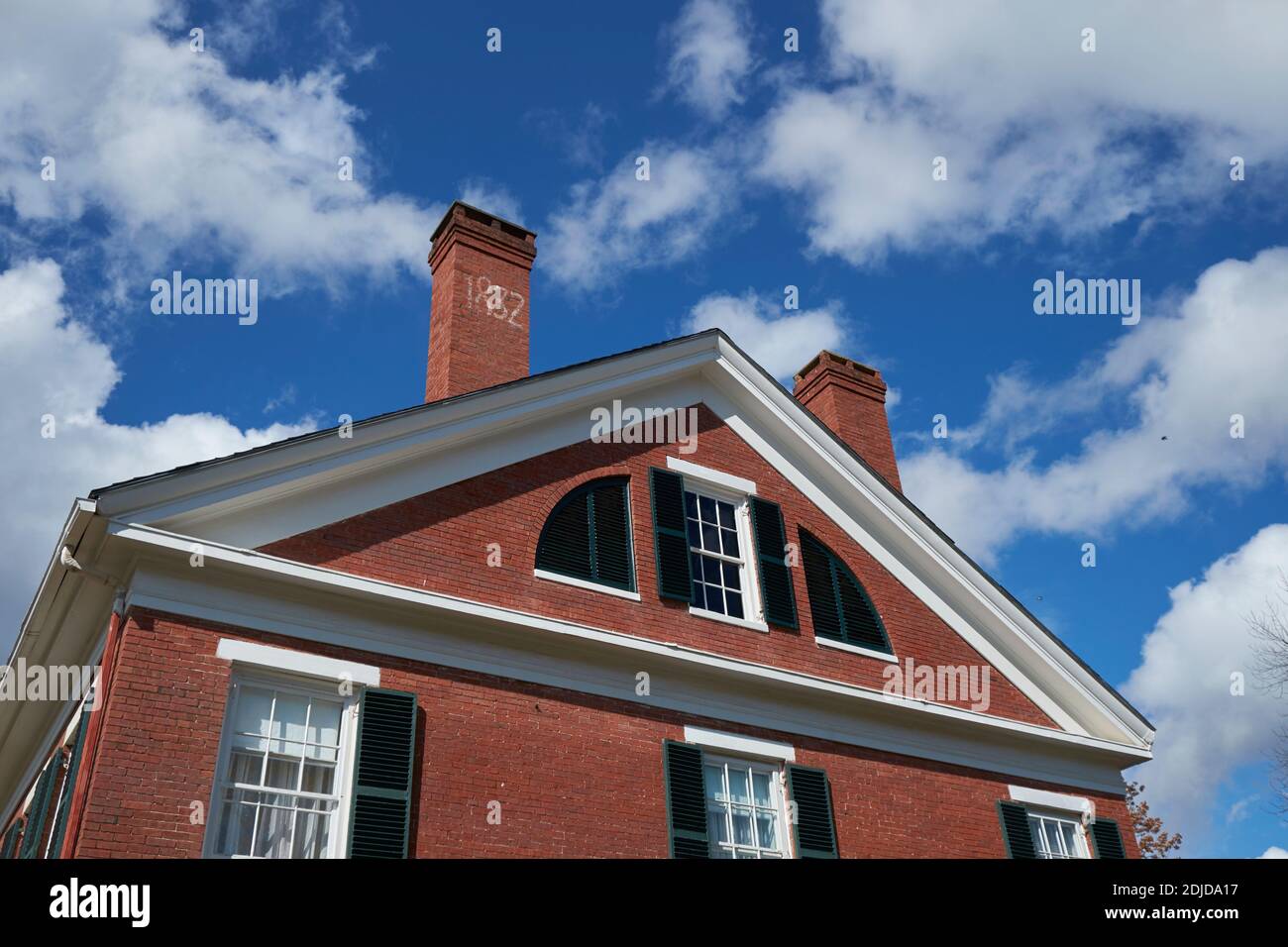 Dach- und Kamindetails eines schönen Beispiels eines schicken, alten, historischen, roten Backsteinhauses in Belfast, Maine. Stockfoto