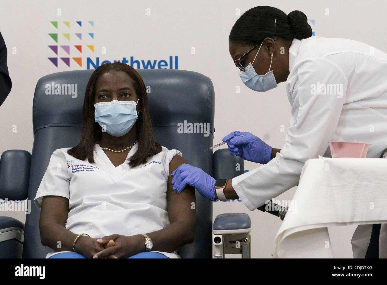 Queens, Usa. Dezember 2020. Sandra Lindsay, links, eine Krankenschwester im Long Island Jewish Medical Center, wird von Dr. Michelle Chester, Montag, 14. Dezember 2020, im Stadtteil Queens von New York mit dem COVID-19-Impfstoff geimpft. Die Einführung des Pfizer- und BioNTech-Impfstoffes, der erste, der von der Food and Drug Administration zugelassen wurde, eröffnet die größte Impfkampagne in der Geschichte der USA. Pool Foto von Mark Lennihan/UPI Kredit: UPI/Alamy Live Nachrichten Stockfoto