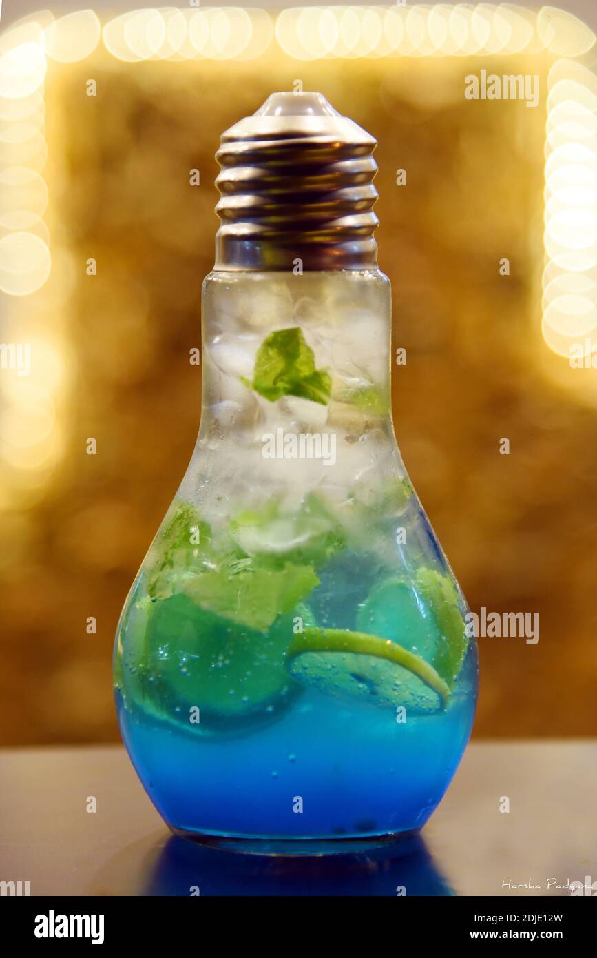 Blaue Lagune Mojito in einem birnenförmigen Glas. Blaue Farbe Limonade mit Eis und Minze Blatt in einem Glas. Stockfoto