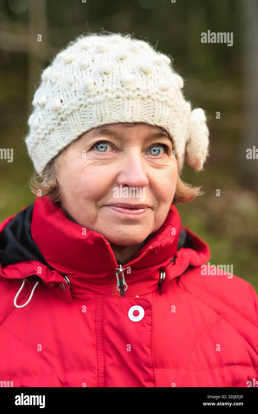 Portait von Frau mittleren Alters, die im Winter auf die Kamera schaut Tücher Stockfoto