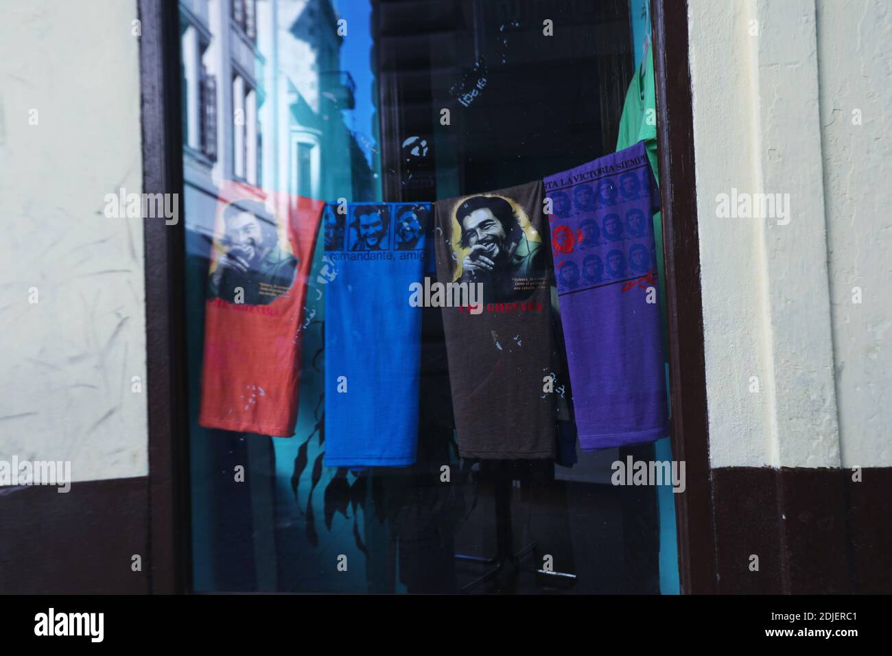 Ein gerahmtes Bild von Che Guevera hängt an einer Mauer gleich neben Tragetaschen in eine Straßenseite Souvenir-Shop. Alt-Havanna, La Habana, Kuba Stockfoto