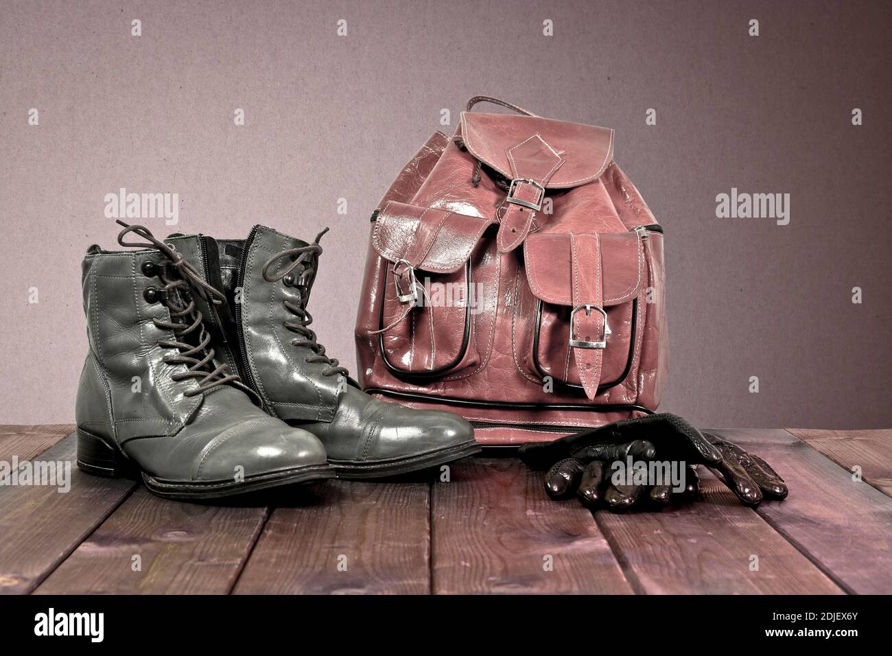 Vintage Stiefel aus echtem Leder und Rucksack aus Leder auf Holzboden. Konzept der Wandertouren. Stockfoto