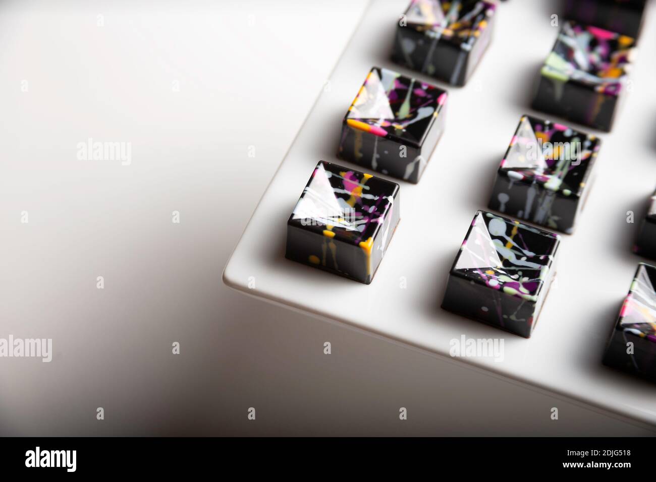 Luxus Schokolade handgemachte Bonbons mit Ganache mit bunten abstrakten Kunst auf weißem Hintergrund dekoriert. Exklusiver handgefertigter Bonbon Stockfoto