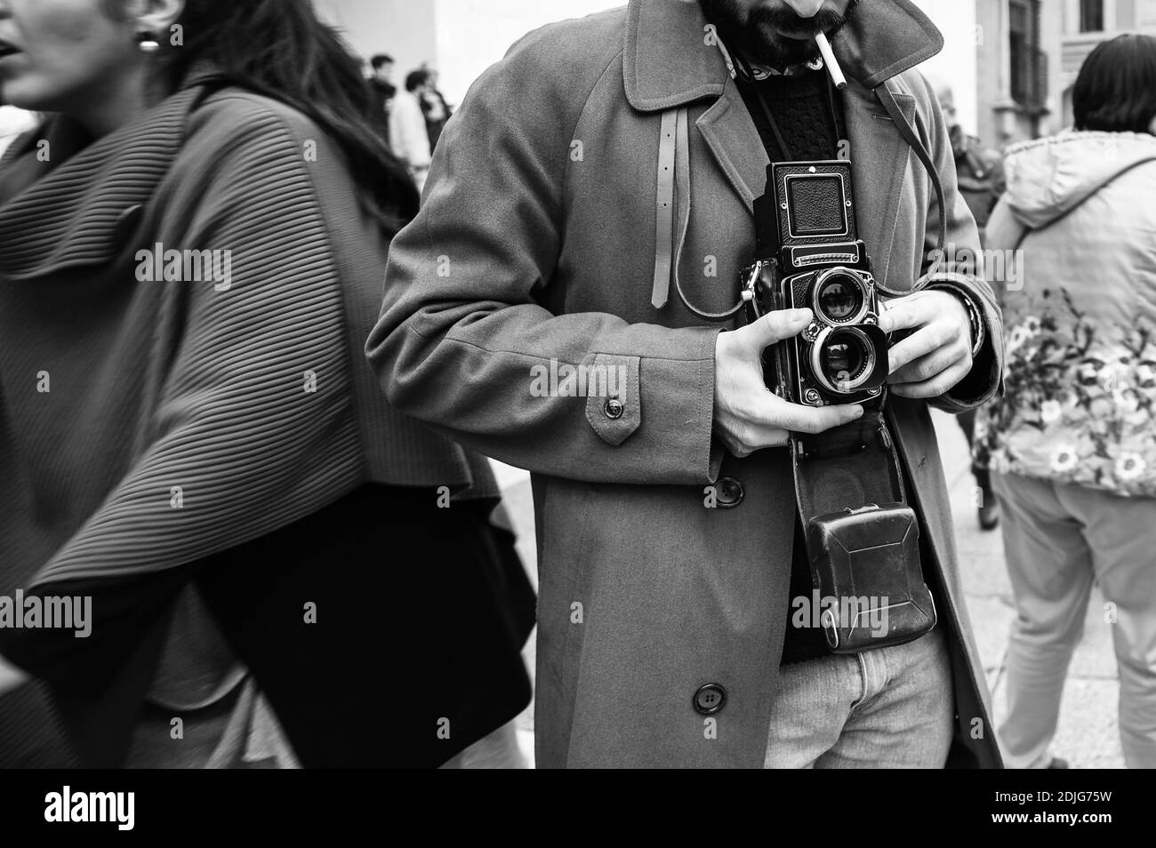 Hipster Kerl mit der Vintage-Kamera fotografieren Menschen in der Stadt - Fotojournalist mit einer berühmten Retro-Kamera fotografieren In der Menge während der Straße Stockfoto