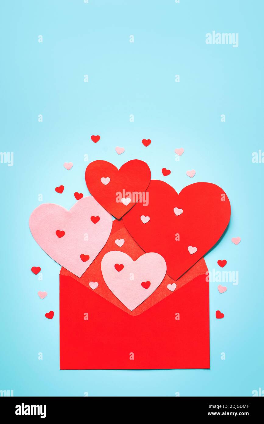 Alles Liebe zum Valentinstag.Rote Umschlag und rote Herzen auf blauem Hintergrund.Valentine Tageskonzept Stockfoto