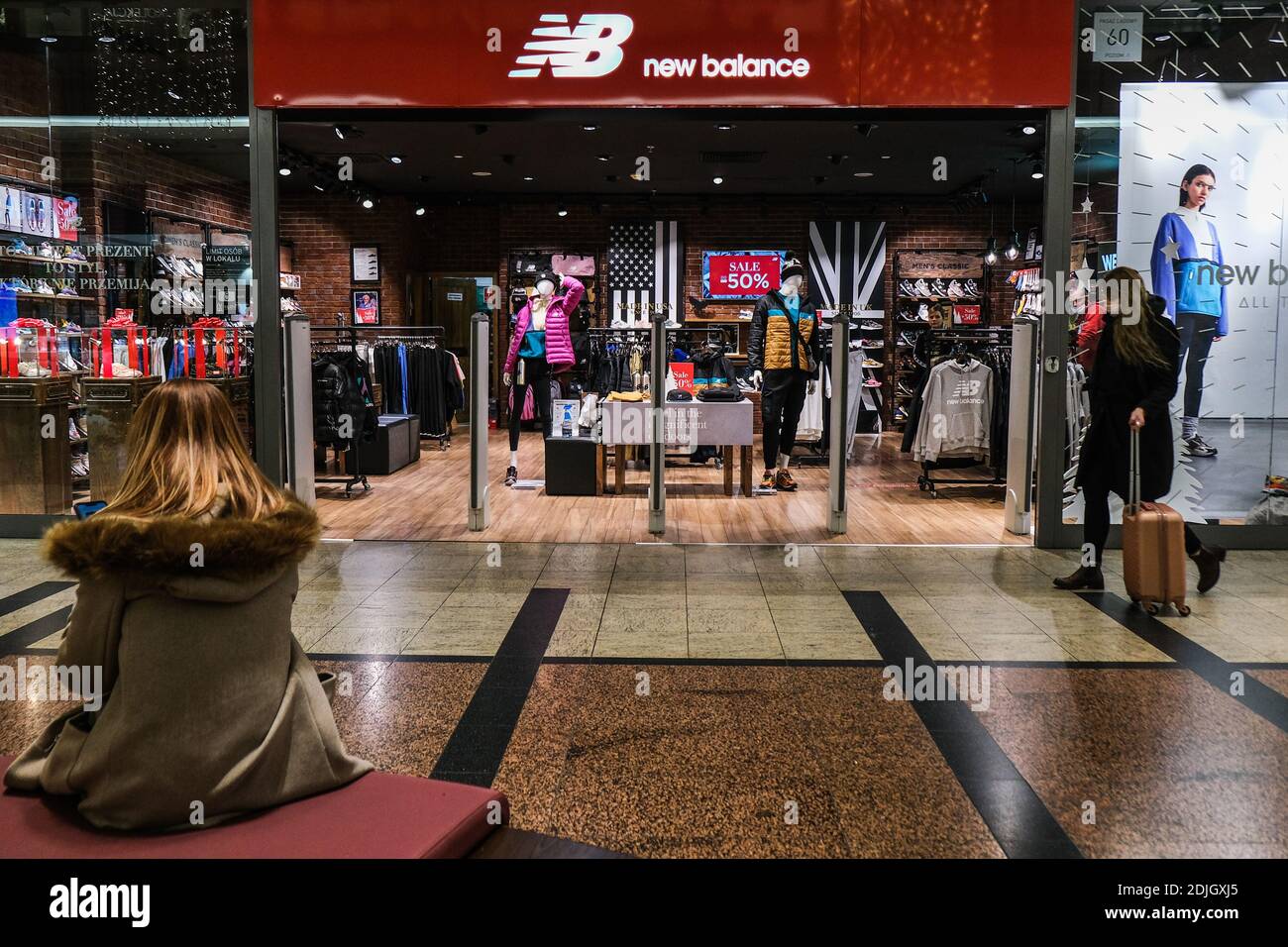 Krakau, Polen. Dezember 2020. Eine Frau geht an einem New Balance Shop in  einem Einkaufszentrum vorbei. Kredit: SOPA Images Limited/Alamy Live  Nachrichten Stockfotografie - Alamy