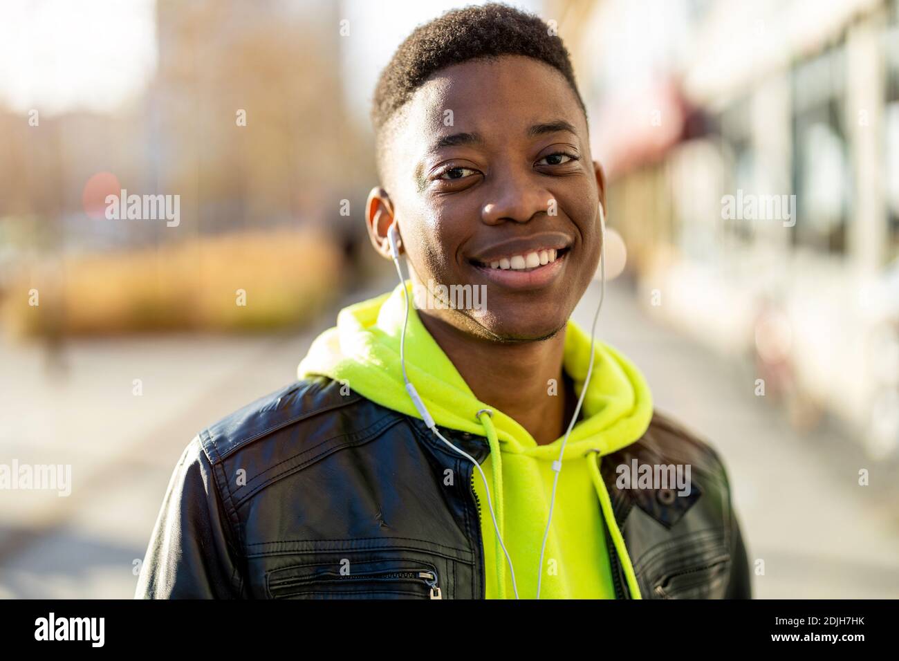 Porträt eines jungen Mannes, der in einer Stadtstraße steht und lächelt Stockfoto