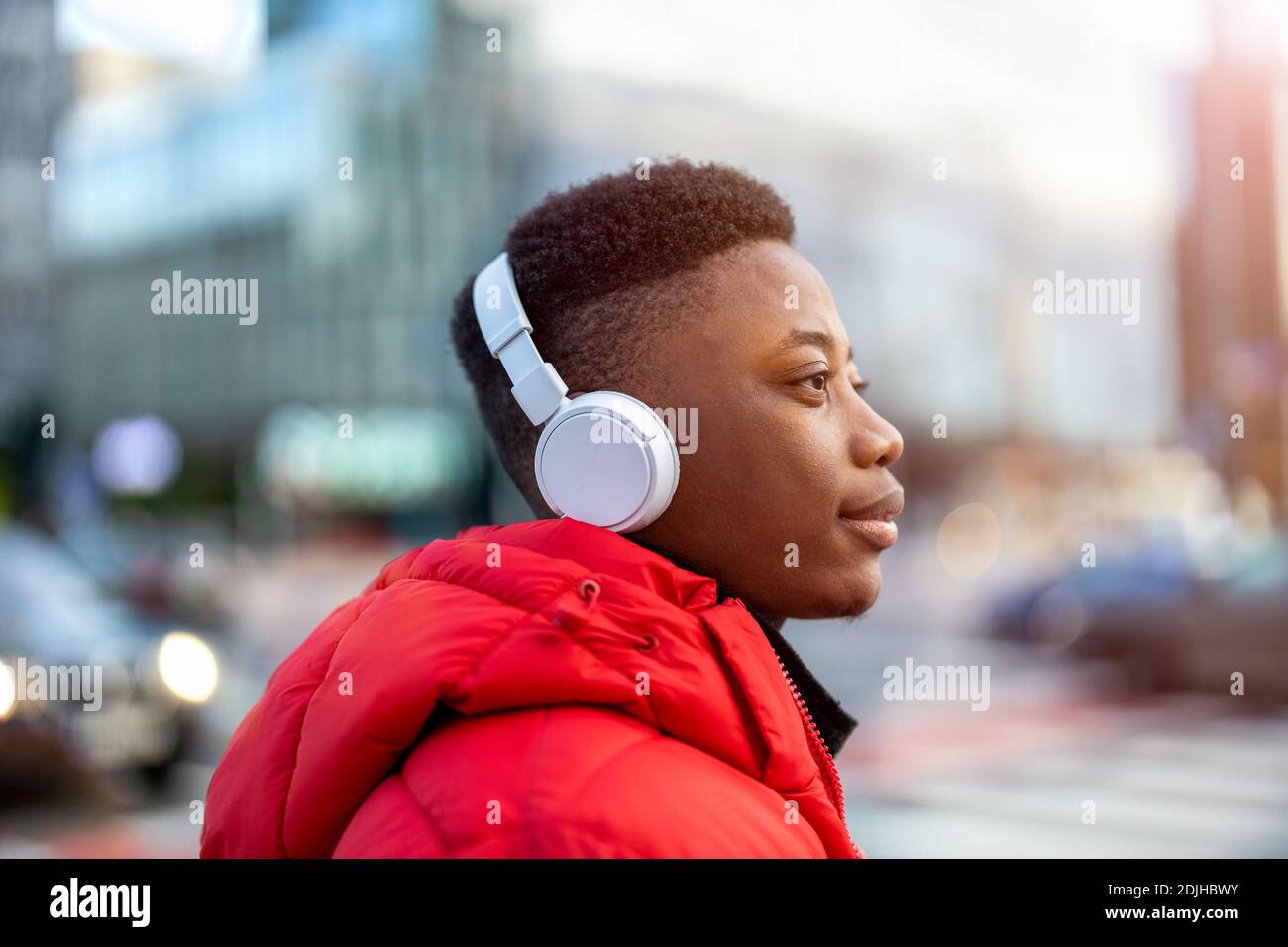 Junger Mann mit Kopfhörern und Musik hören in der Stadt Stockfoto
