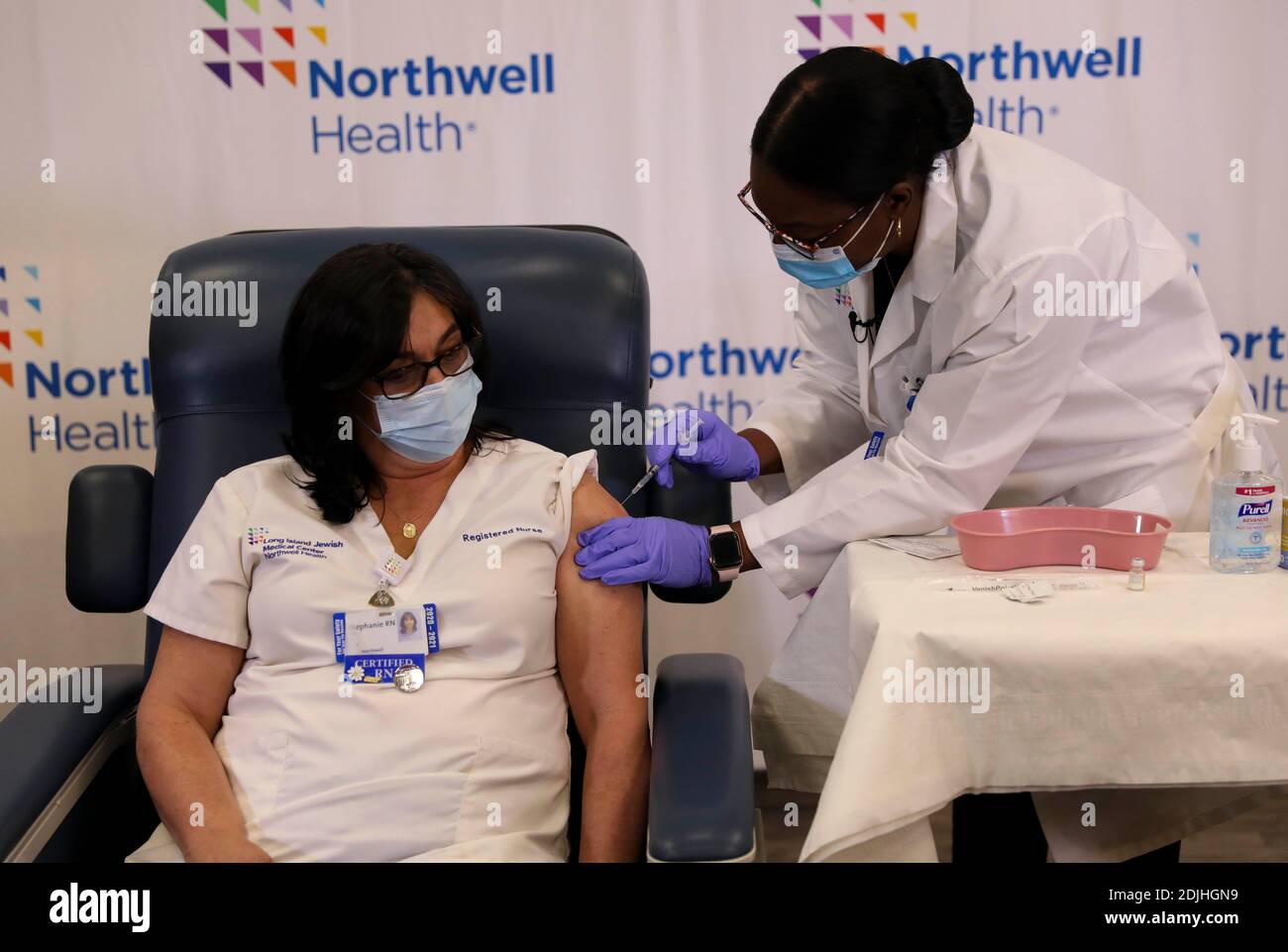 New York, USA. Dezember 2020. Stephanie Cal (L), Krankenschwester am Long Island Jewish Medical Center, wird am 14. Dezember 2020 in New York, USA, mit dem COVID-19-Impfstoff geimpft. Die Vereinigten Staaten begannen am Montag mit der Einführung ihres ersten COVID-19-Impfstoffs, da die ersten Dosen an Mitarbeiter im Gesundheitswesen und Pflegepersonal verabreicht wurden. Quelle: Wang Ying/Xinhua/Alamy Live News Stockfoto